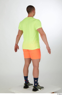 Joel a-pose dressed green sneakers orange shorts sports standing whole…